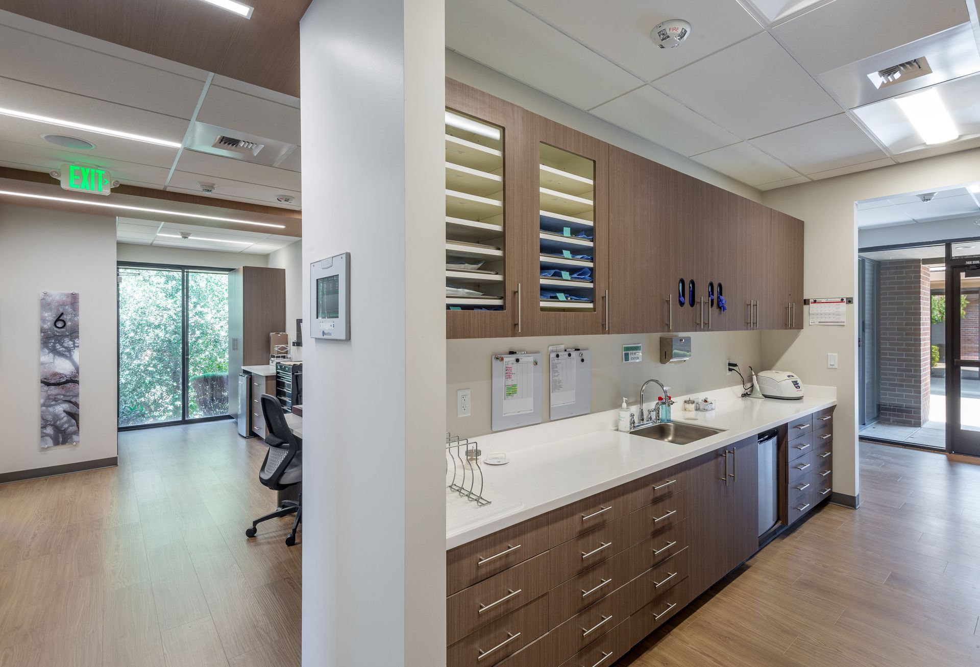 Hallway with open doorway revealing a medical room. A door with handle slides open to the left. Number