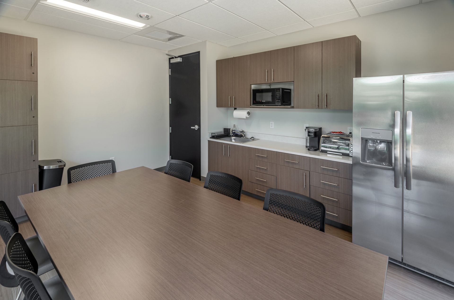 Open doorway to a room with three gas cylinders and equipment mounted on the wall. The cylinders are blue, green, and grey.
