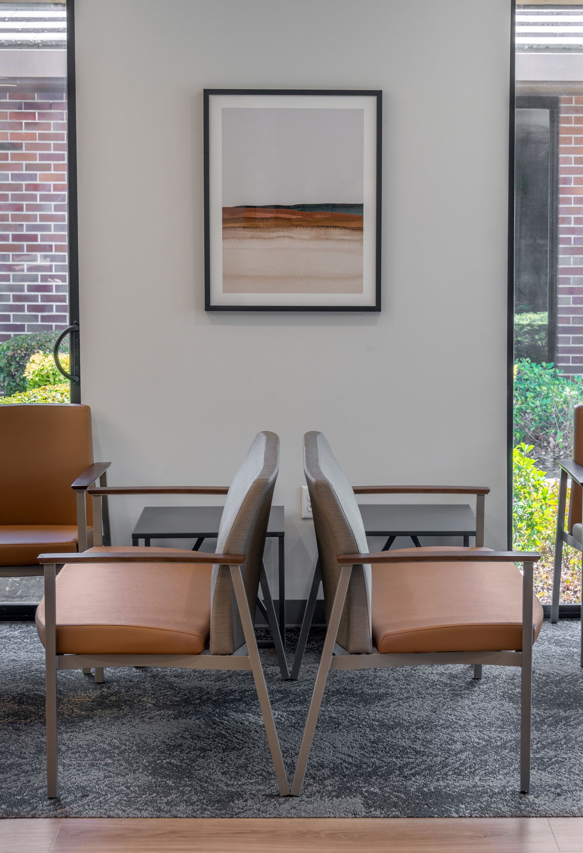 Cozy booth with a bench seat, scenic mural, and recessed lighting. Located in an office space near a window and doorway.