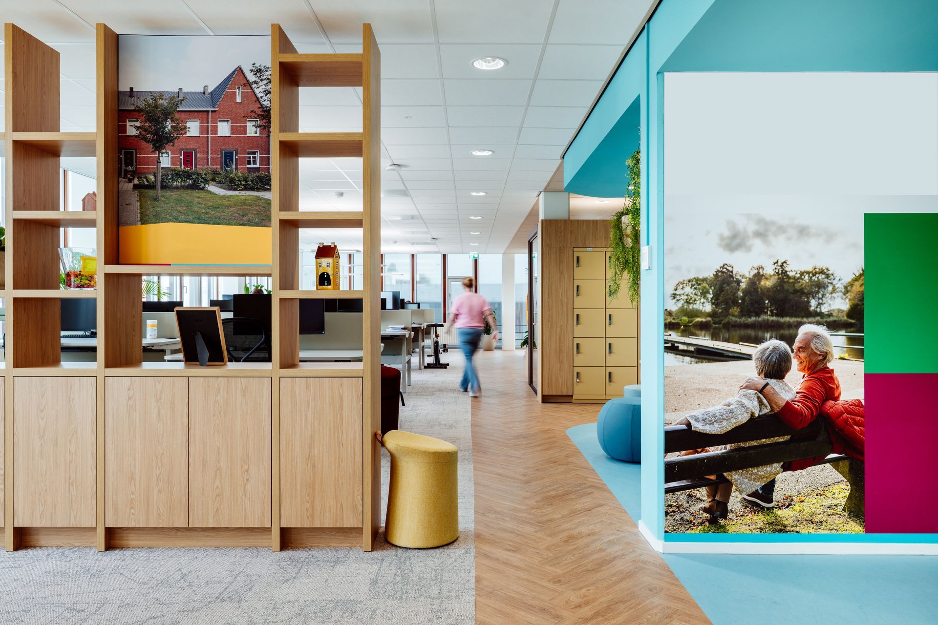 Moderne kantoorlounge met houten planken, een turquoise muur en een kleurrijke fotomuur.