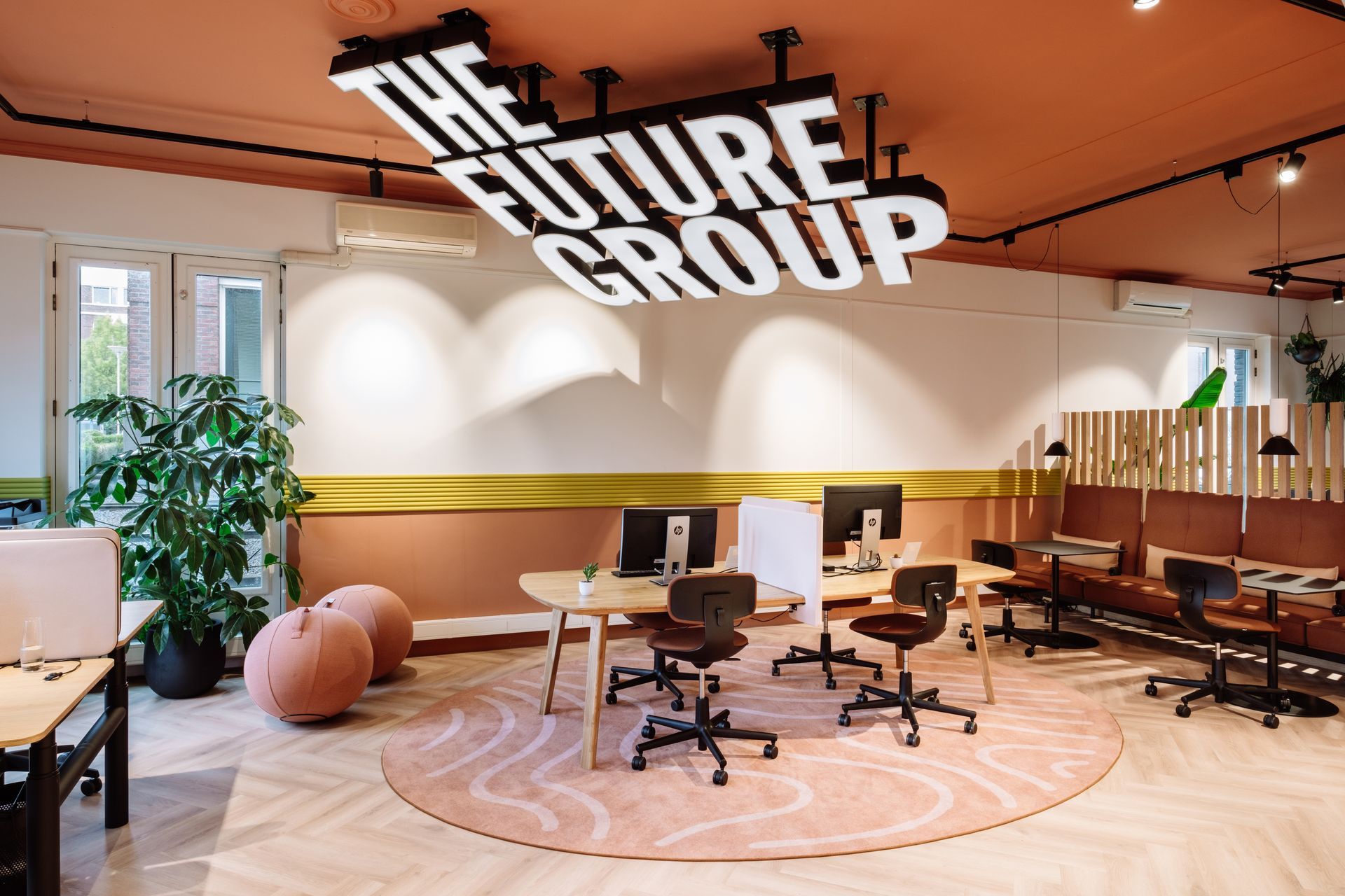 Moderne kantoorlounge met bureaus, stoelen, planten en een groot