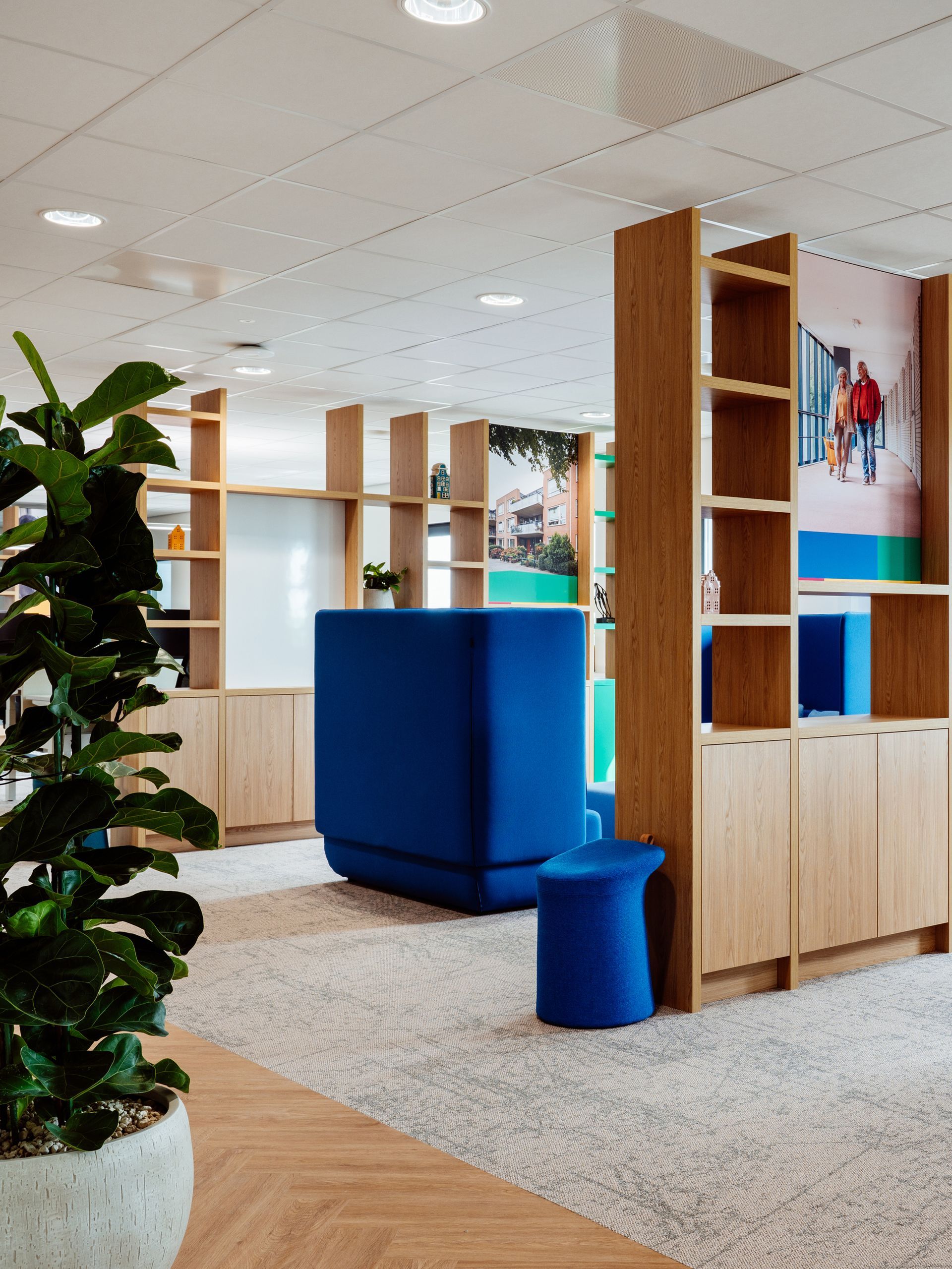 Een licht, modern kantoor met potplanten in houten plantenbakken bij een groot raam van EBH Legal, interieurontwerp door KuóStudio