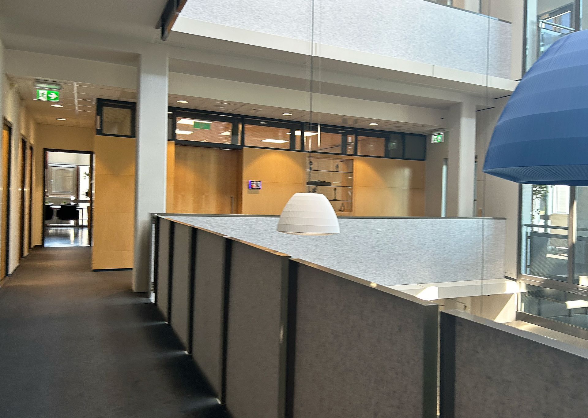 Voor verbouwing: Gedateerde kantoorhal met werkplekken. Gesloten kantoren