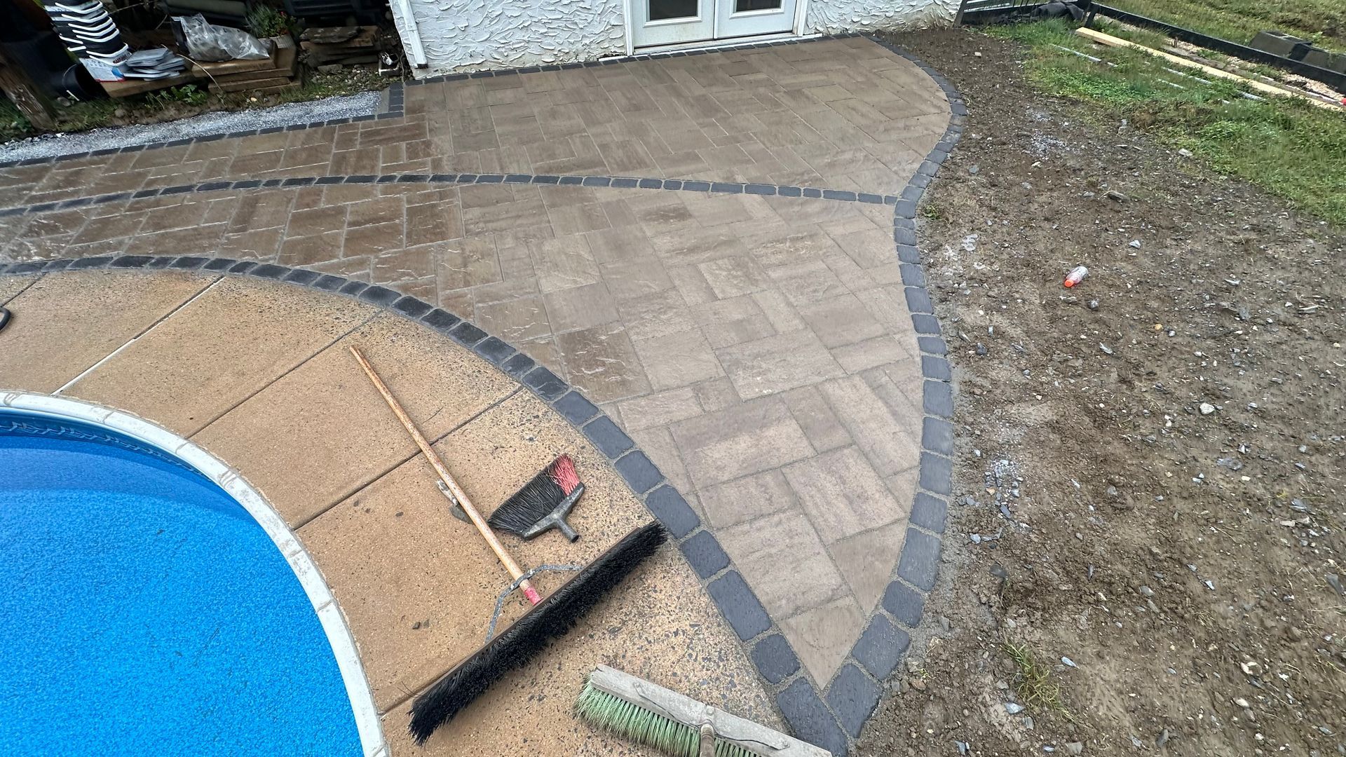 A patio is being built around a swimming pool.