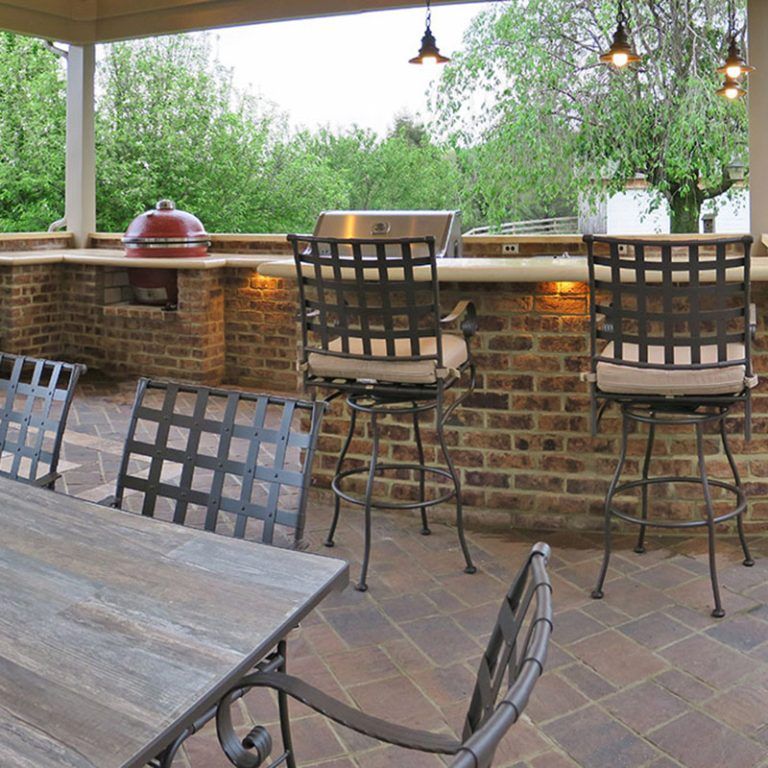 A table and chairs in front of a brick wall