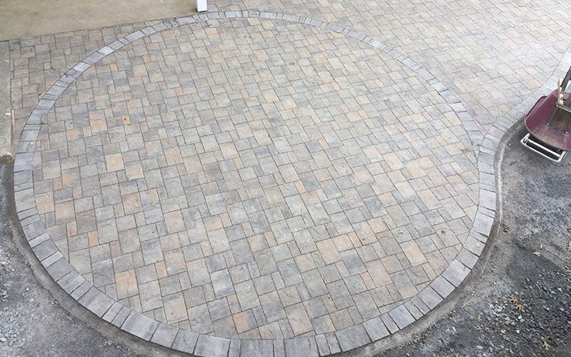 A circular patio made of bricks is being built