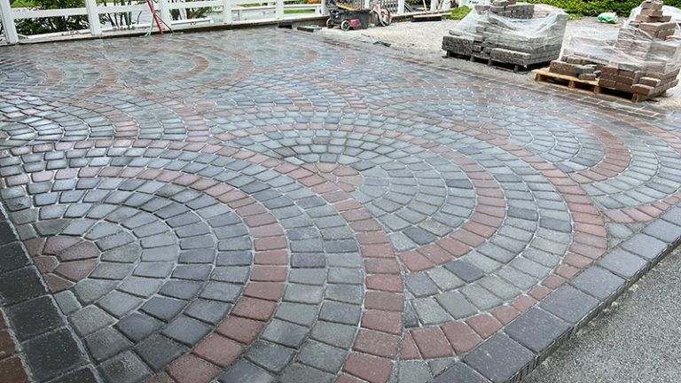 A brick driveway with a circular pattern is being built.