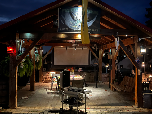 A patio with a brick fireplace and a grill