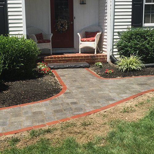 A brick walkway leading to the front door of a house.