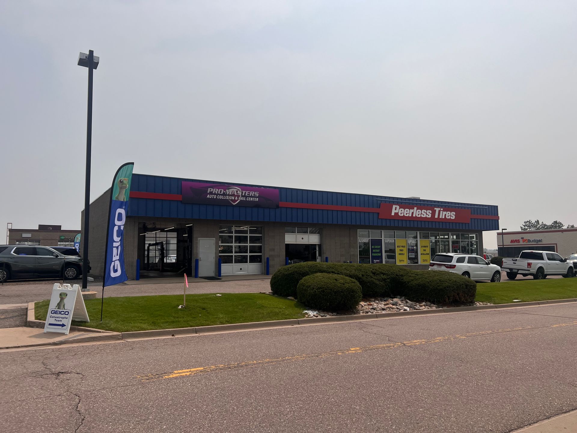 A car wash is located on the side of the road in front of a building.