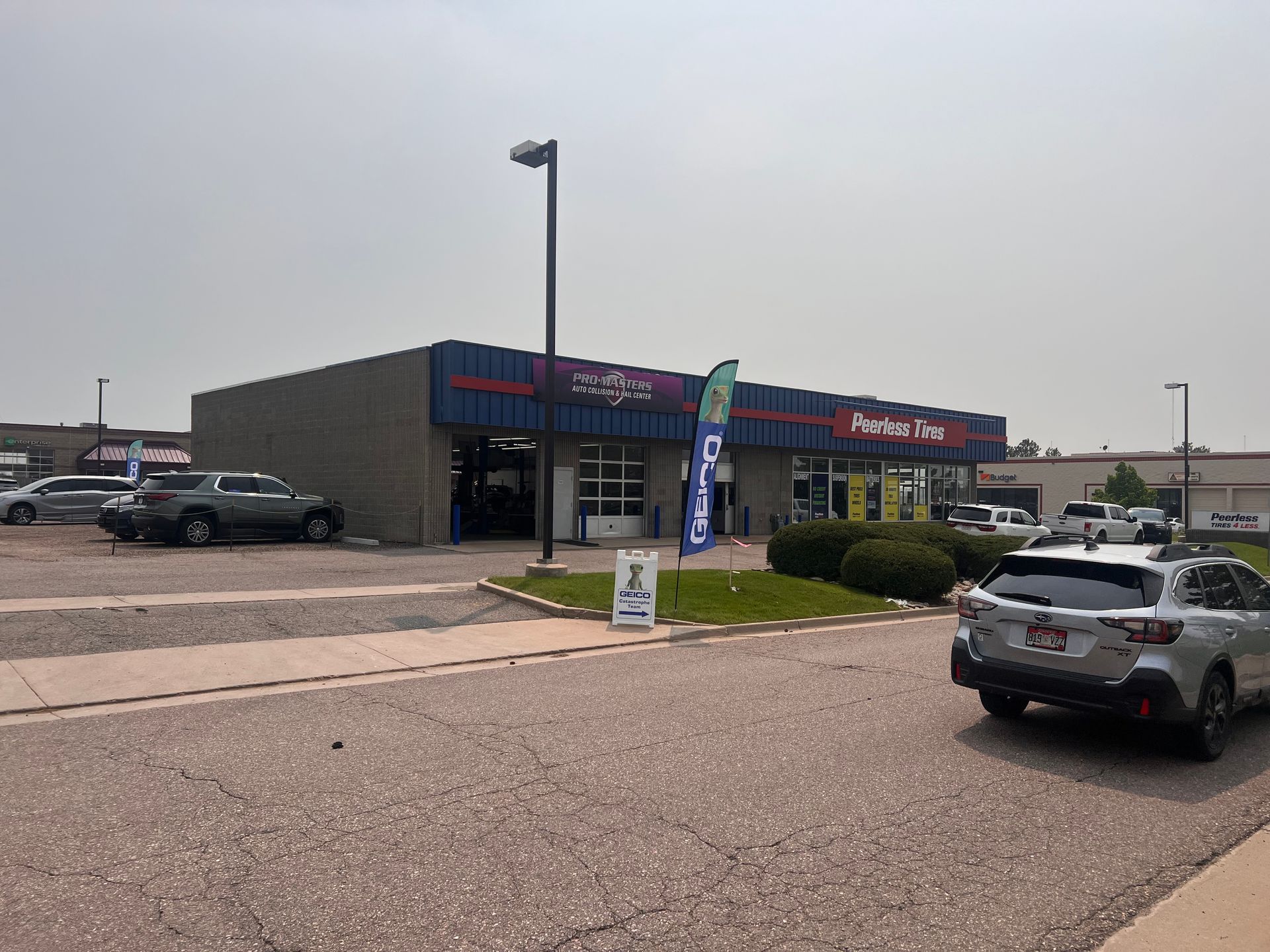 A car is parked in front of a tire shop.