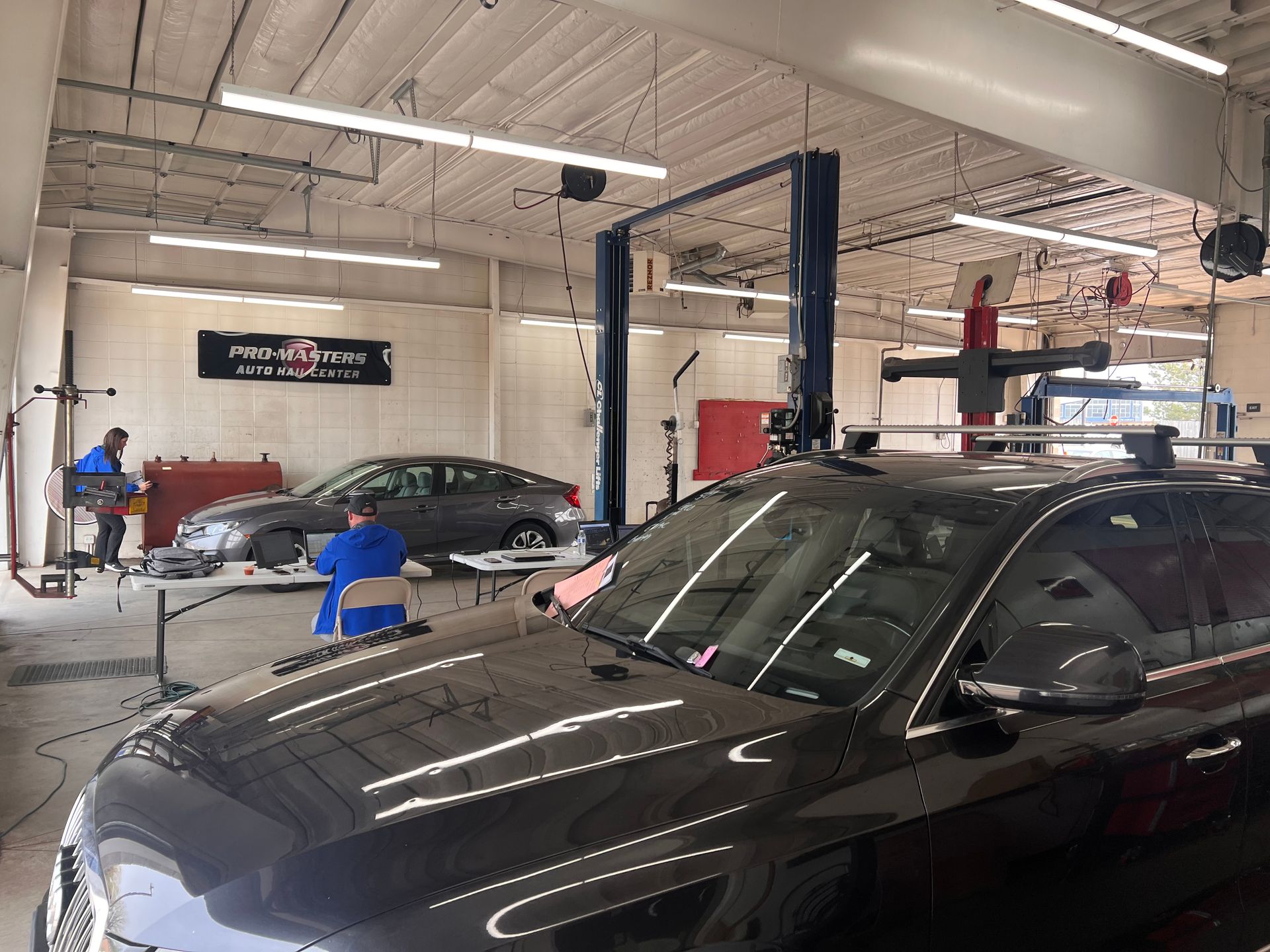 A car is sitting on a lift in a garage.