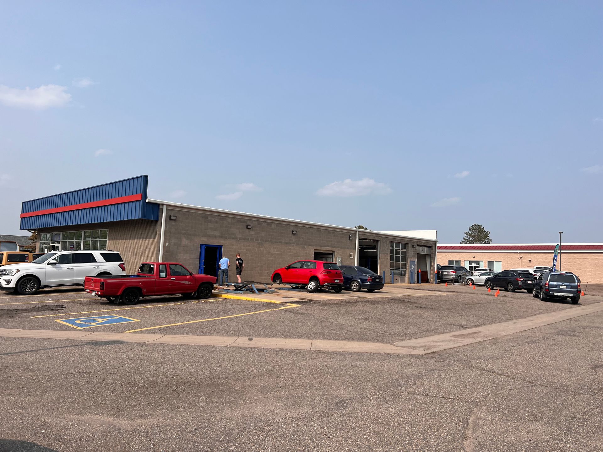 A lot of cars are parked in front of a building.