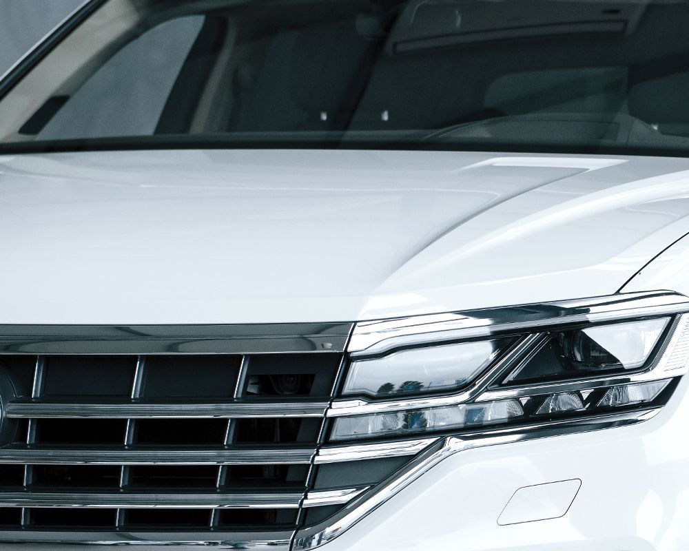 A white car with a chrome grille and headlights