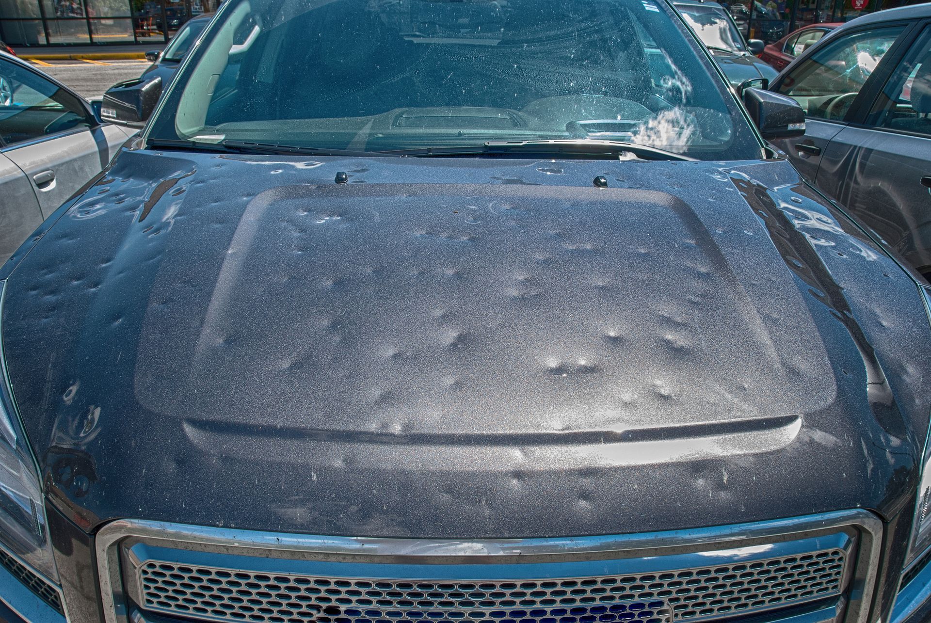 A car with a hood that has been damaged by hail