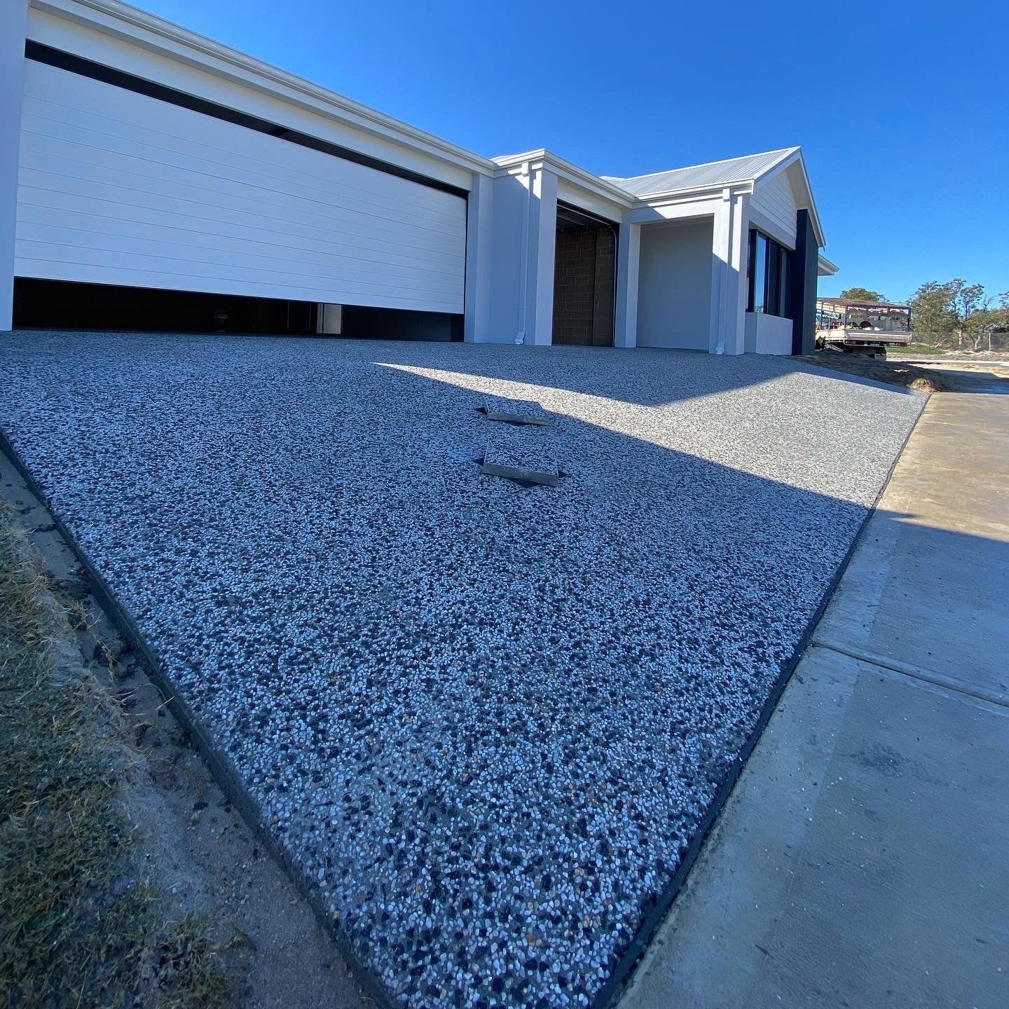 Exposed Aggregate concrete driveway installed in front of the garage