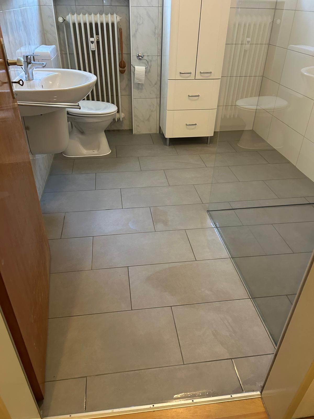 Barrierefreies Badezimmer: schwellenloser Zugang, rutschhemmenden Bodenfliesen, wandhängendem Waschbecken, ebenerdiger Dusche