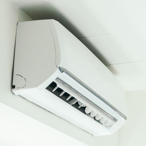 A white air conditioner is hanging from the ceiling