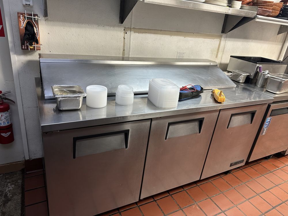 A kitchen with stainless steel appliances and a fire extinguisher.