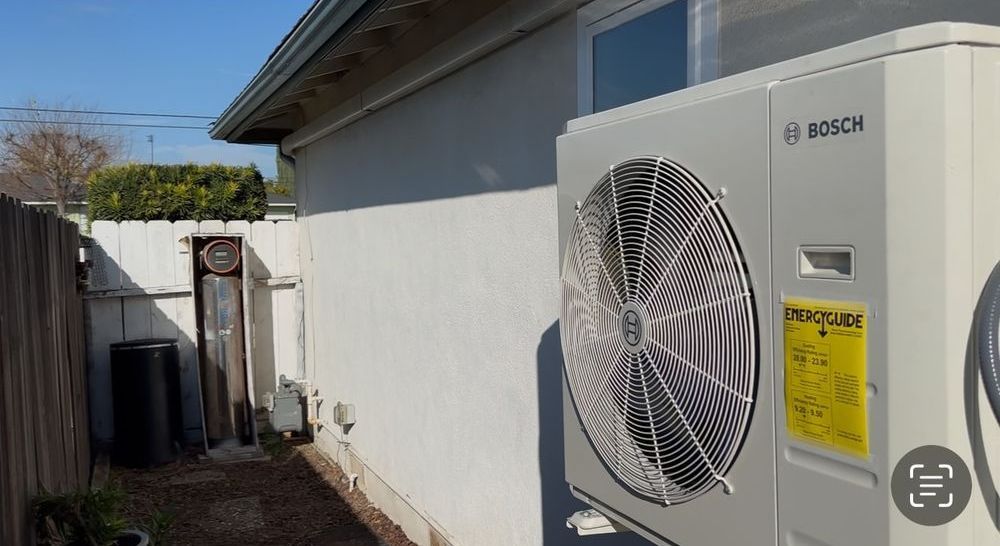 A bosch air conditioner is sitting on the side of a house.