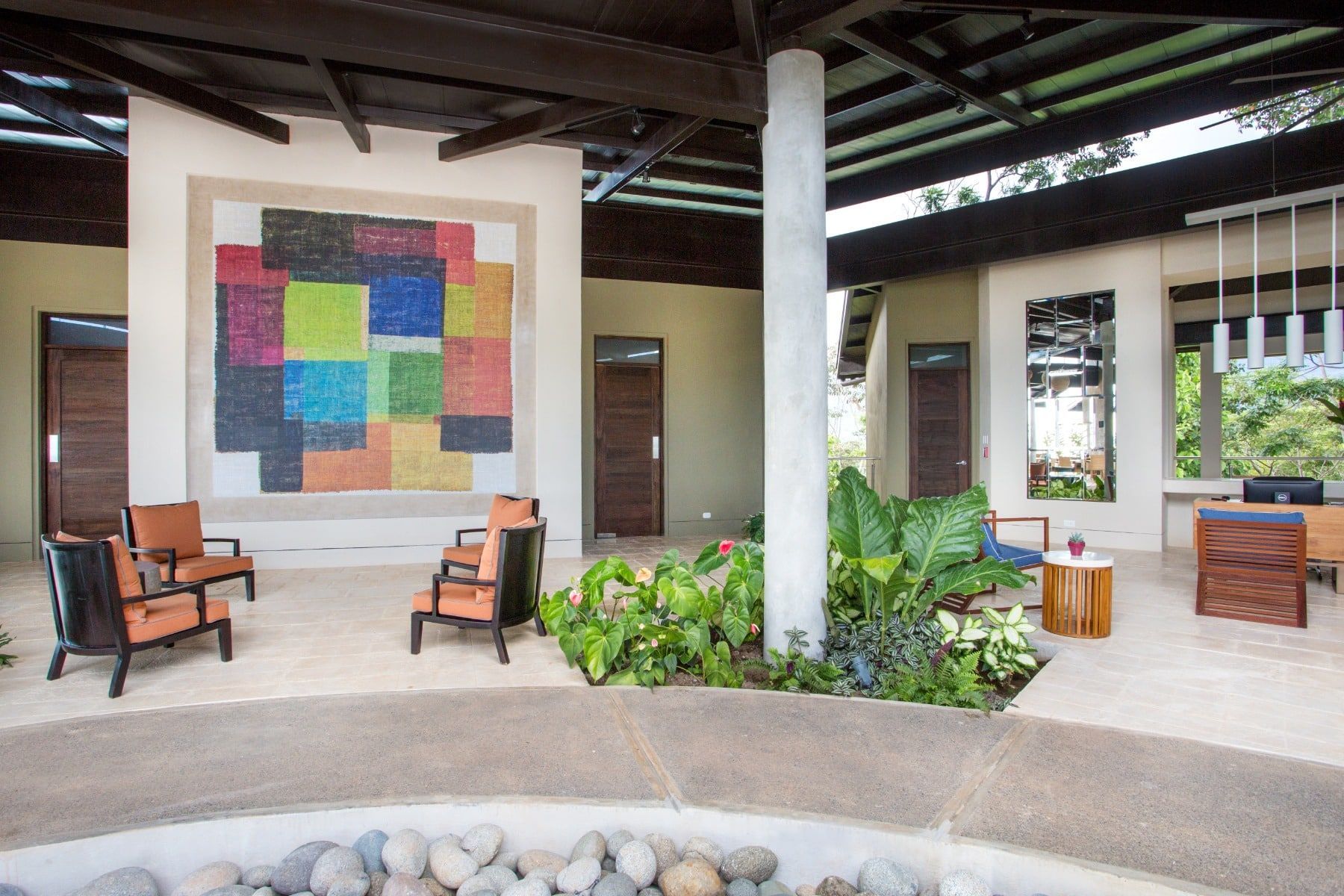 A living room with chairs and a painting on the wall