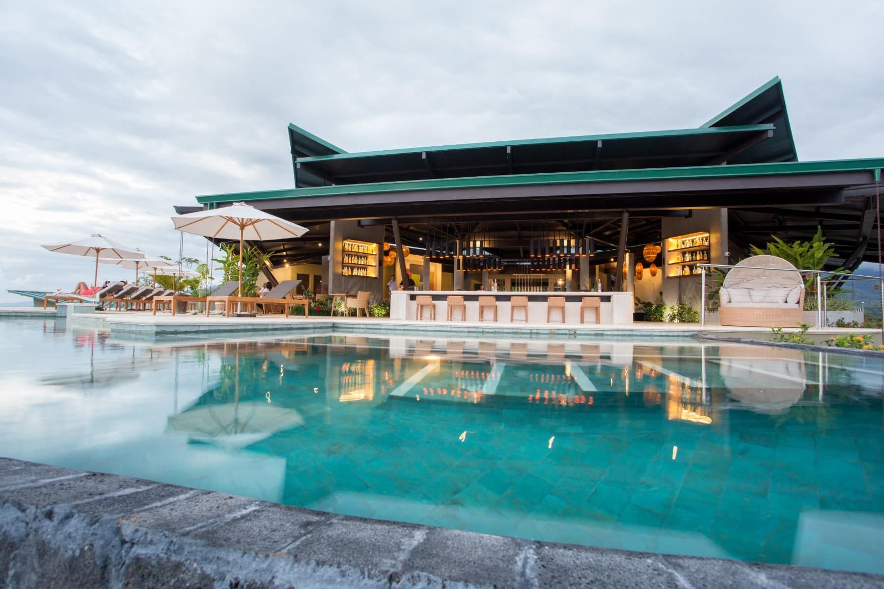 There is a large swimming pool in front of a building.