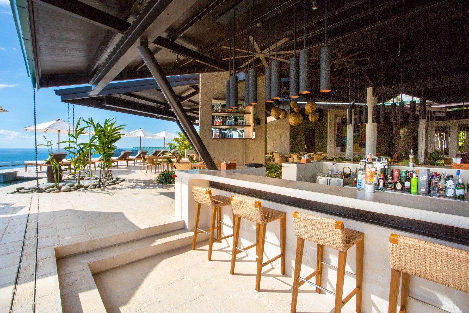 A bar with stools and a view of the ocean