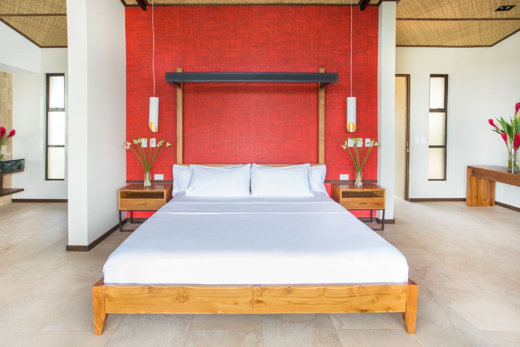 A bedroom with a large bed and a red wall