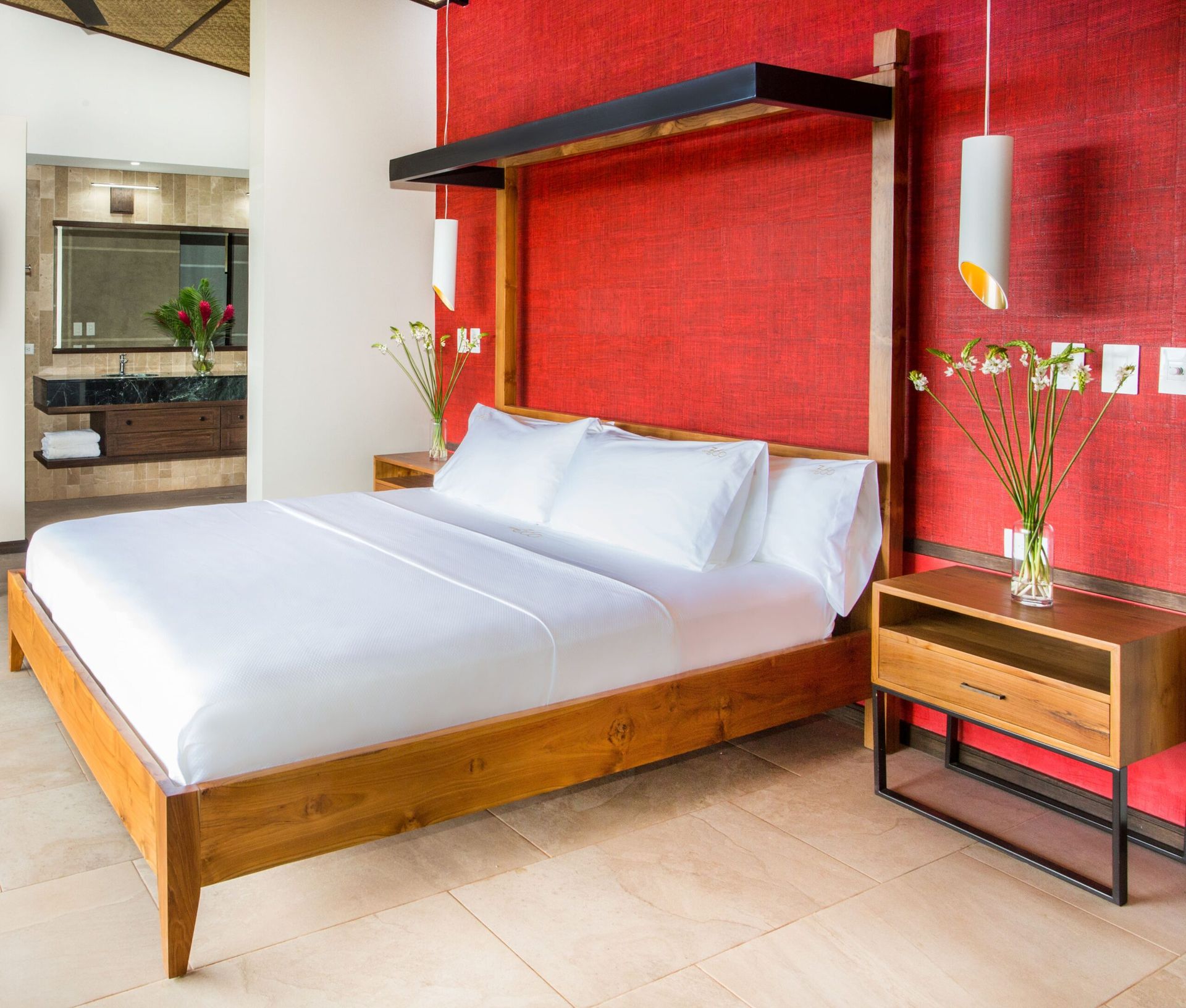 A bedroom with a large bed and a red wall