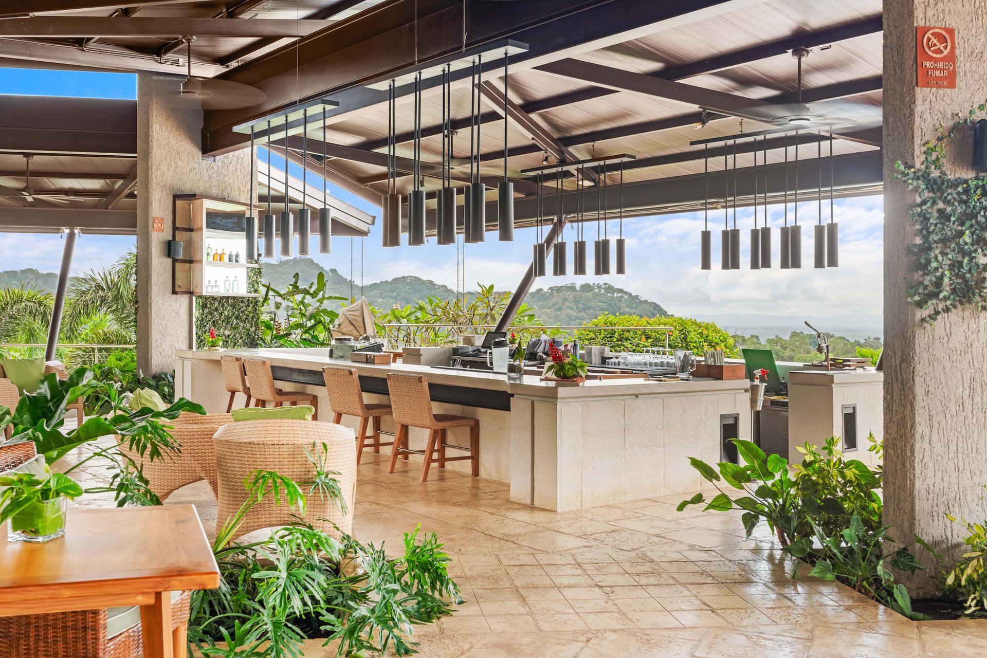 A restaurant with a bar and tables and chairs and a view of the mountains.