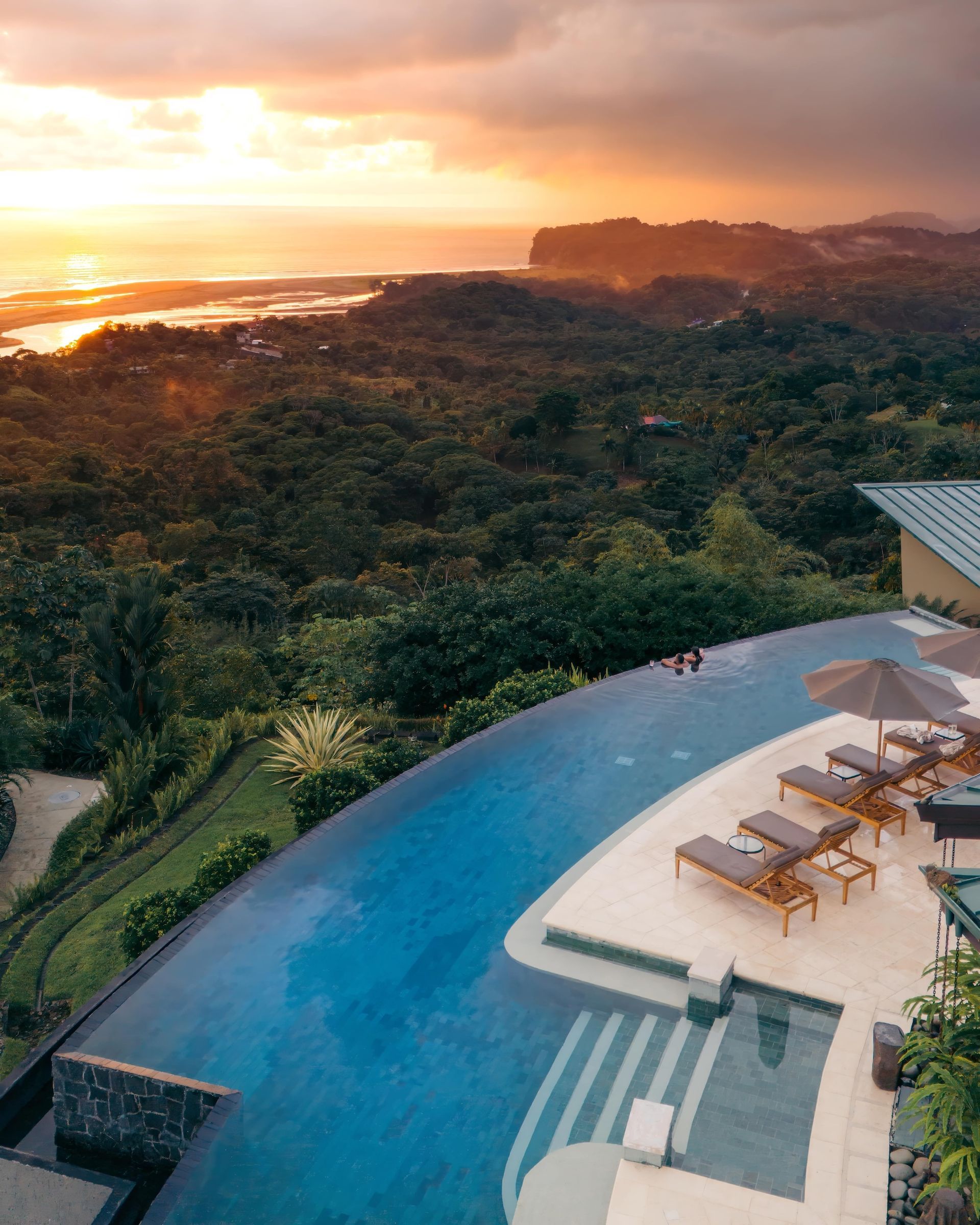 An aerial view of an infinity pool at sunset