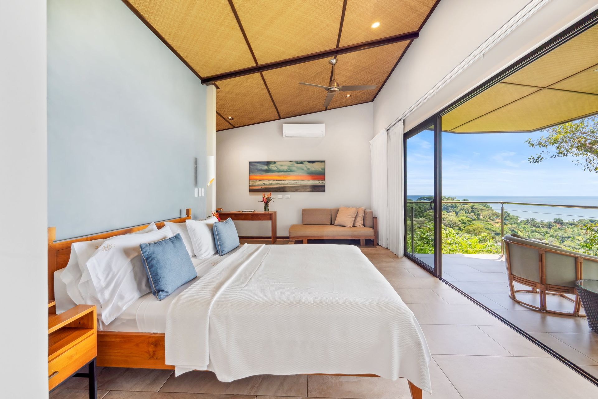 A bedroom with a large bed and a view of the ocean.