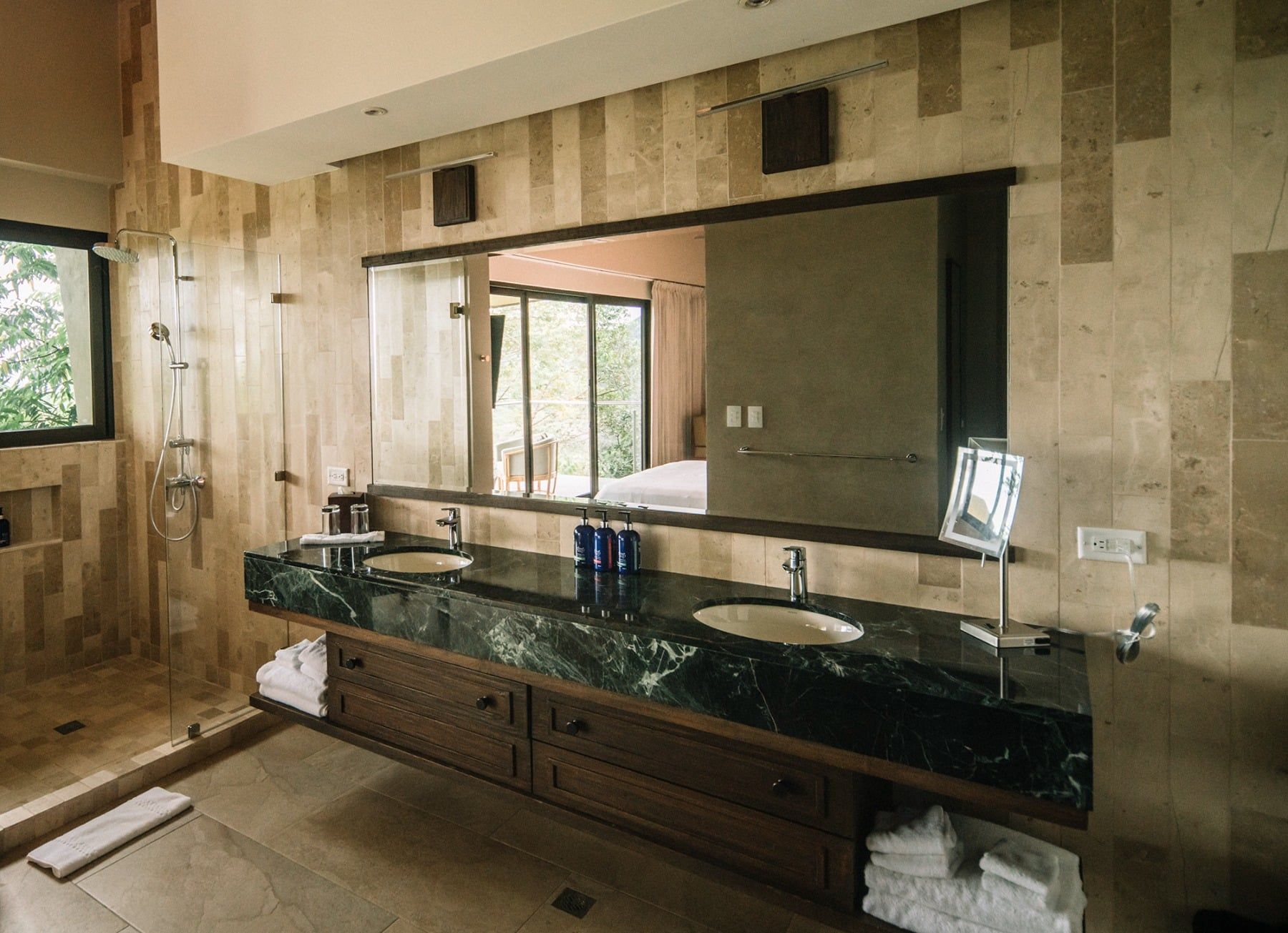A bathroom with two sinks and a large mirror.