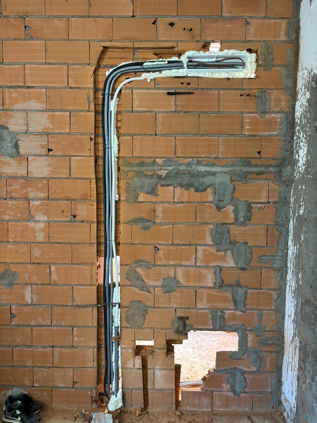 Due grandi caldaie industriali con finitura rossa, argento e grigio scuro, installate in un locale di servizio piastrellato con tubature sovrastanti.