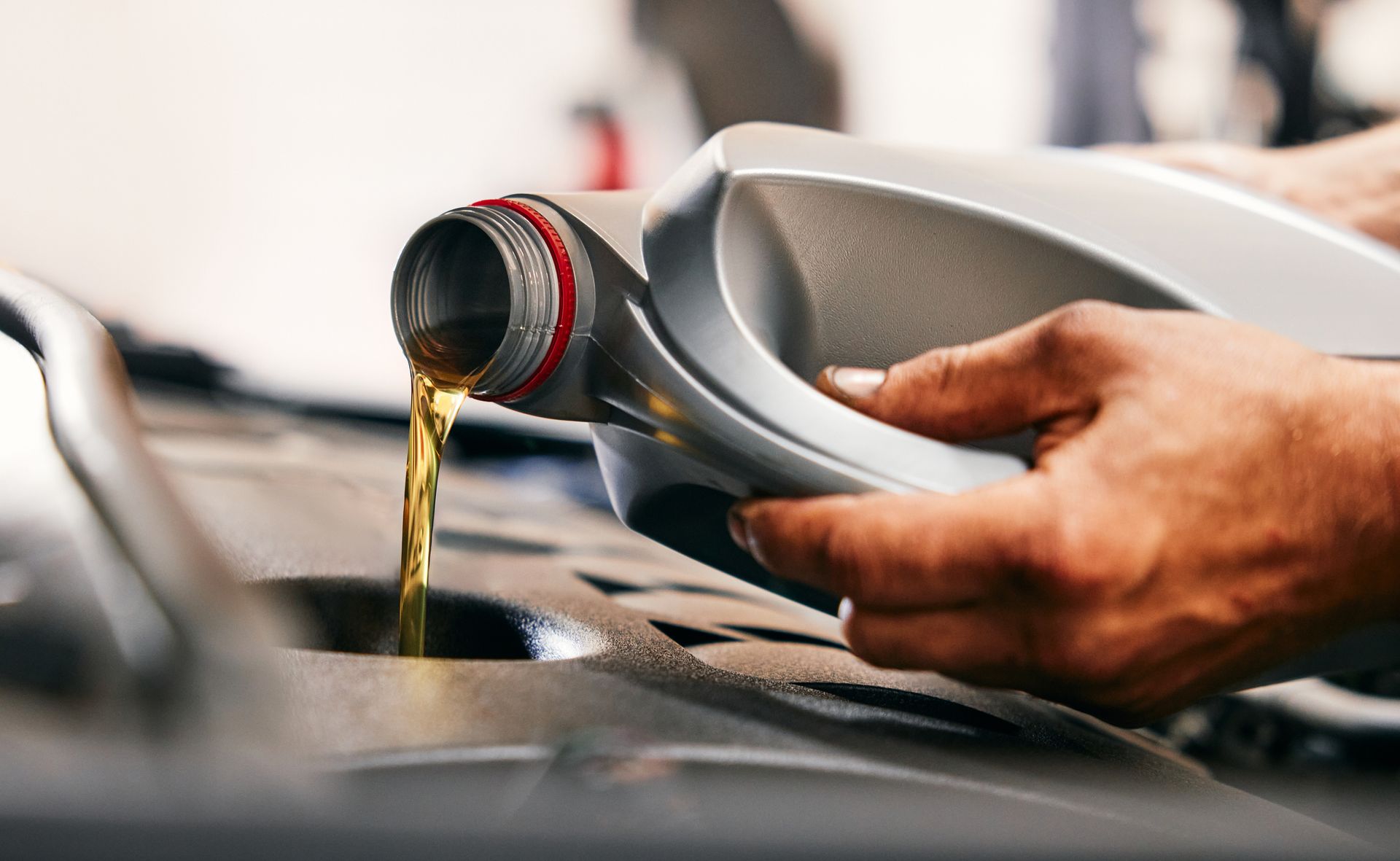 Close-up of car mechanic pouring new oil into engine | Car Oil Change in O'Fallon | O'Fallon Garage 