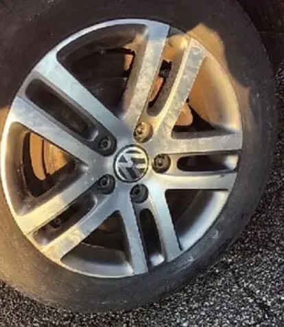 Flat car tire with a Volkswagen wheel.