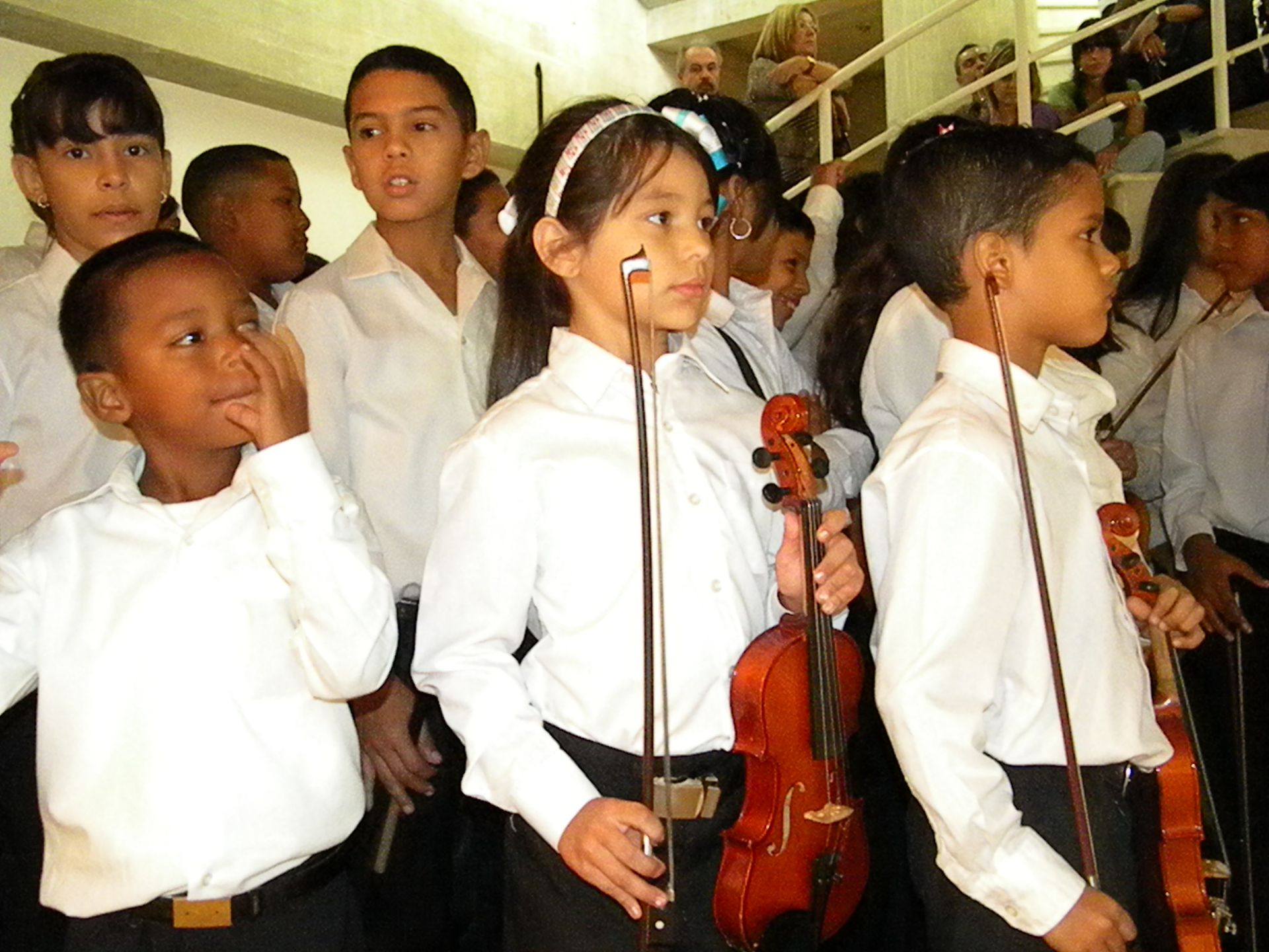 A group of children are playing violins in a choir