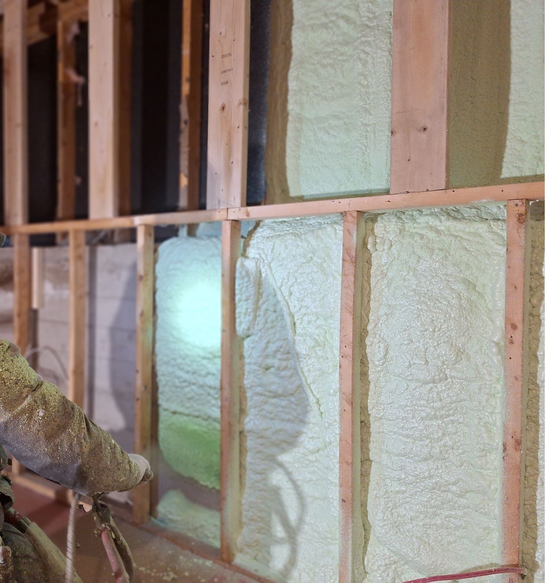 Une personne pulvérise de la mousse sur un mur.