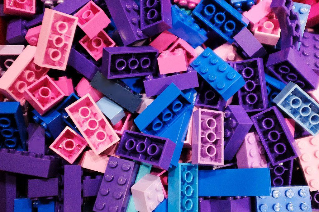 Una pila di mattoncini lego rosa, blu e viola