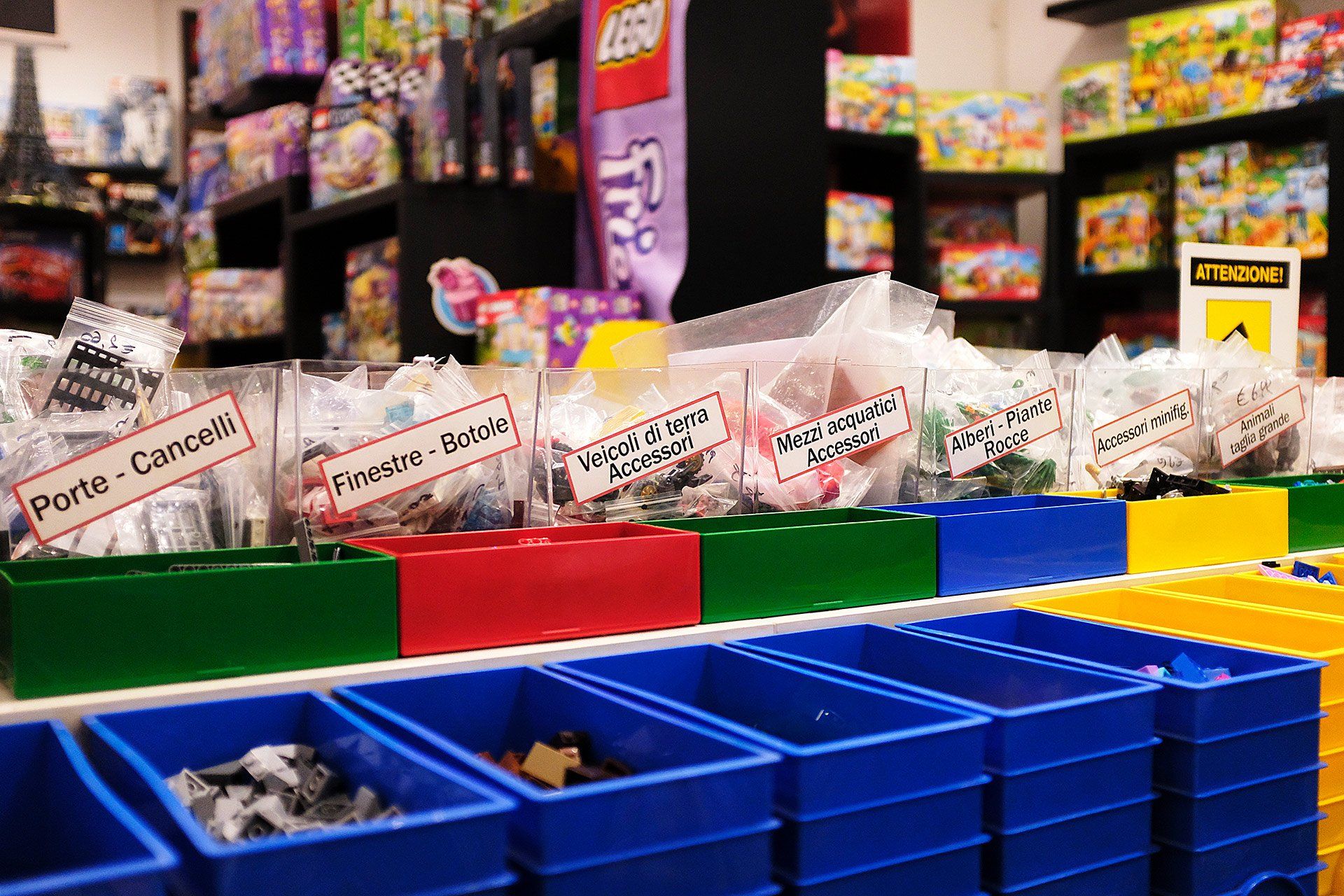 Un negozio pieno di contenitori di plastica colorati pieni di mattoncini Lego.
