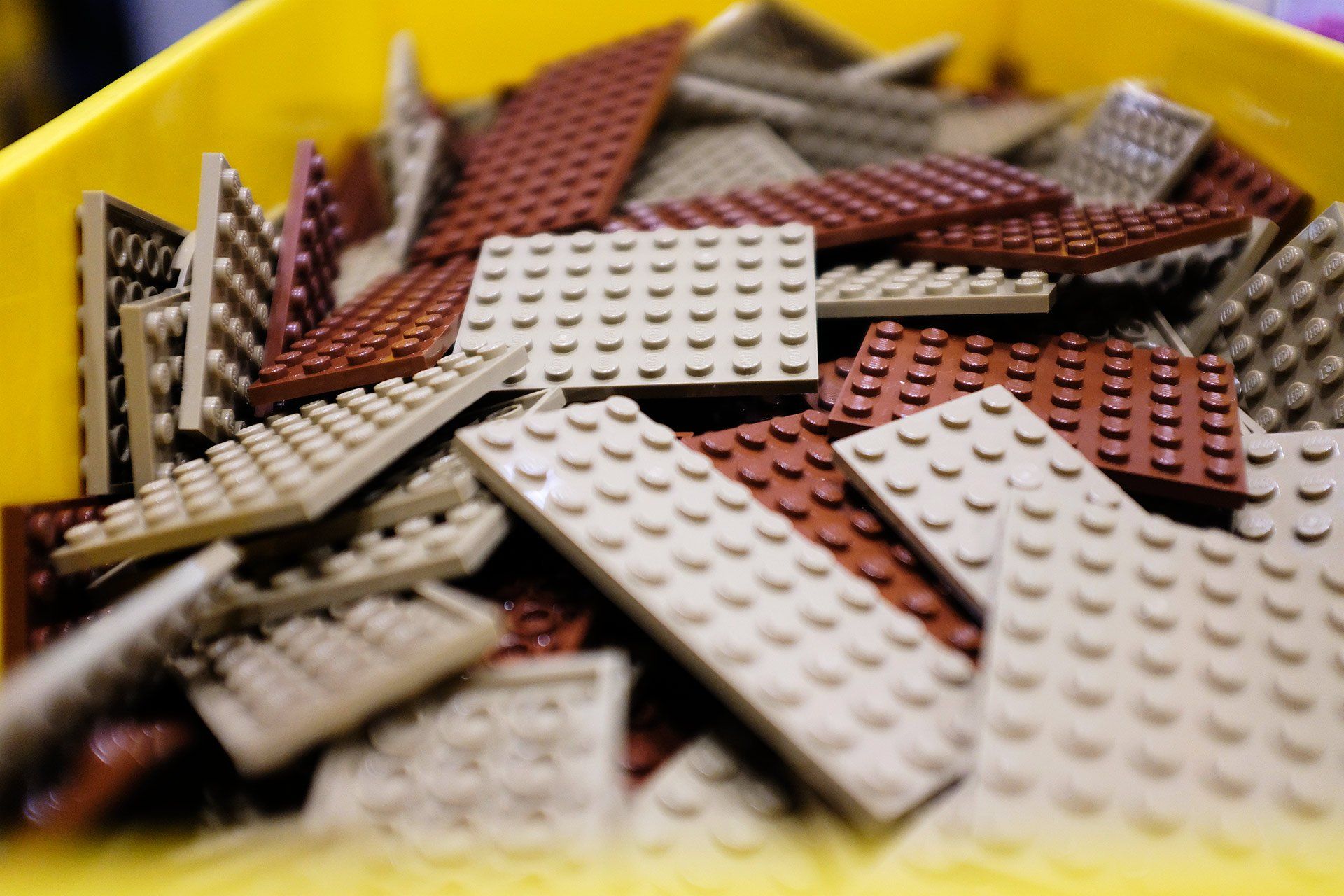 Una pila di mattoncini Lego in un contenitore giallo