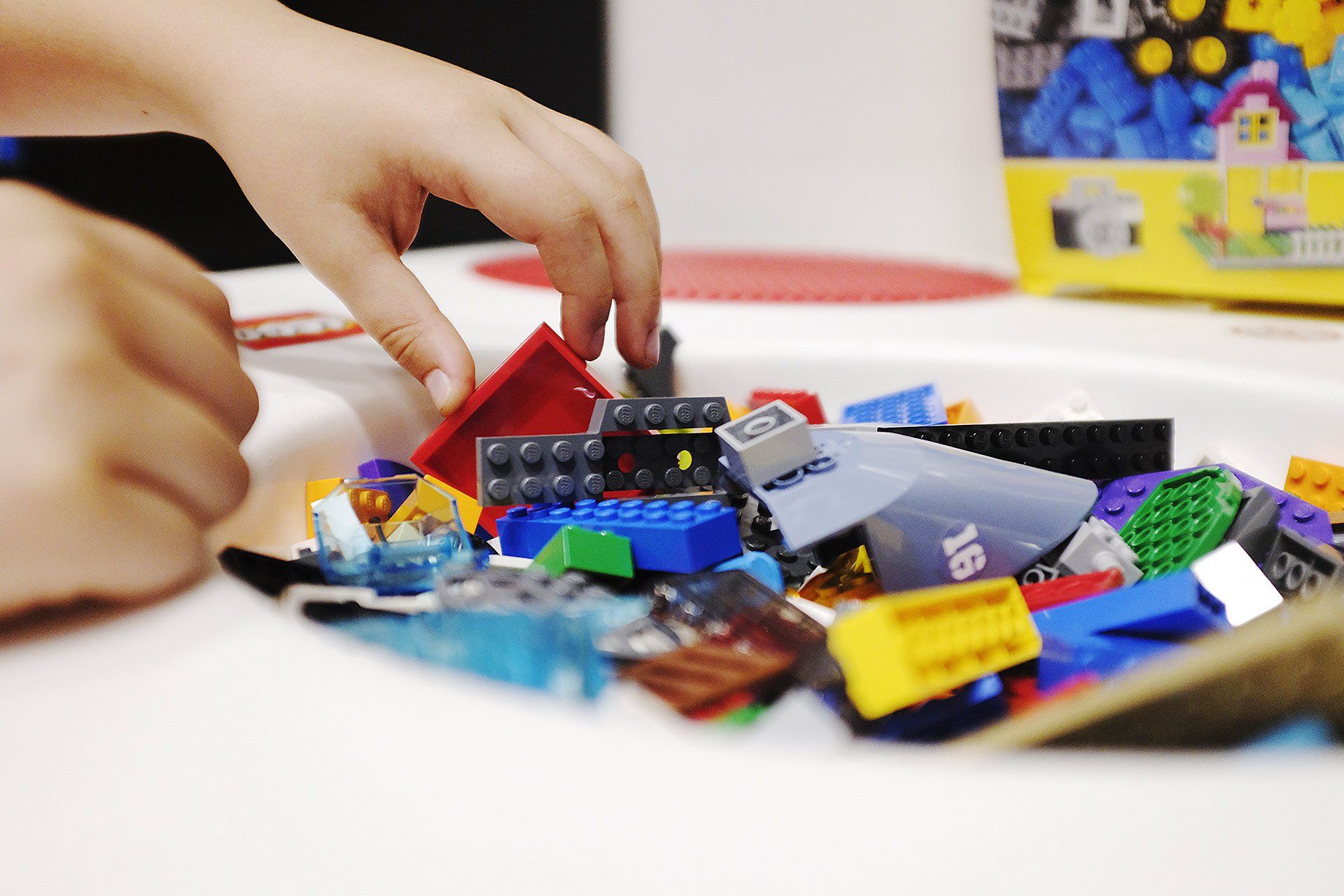 Un bambino sta giocando con una pila di mattoncini Lego su un tavolo.