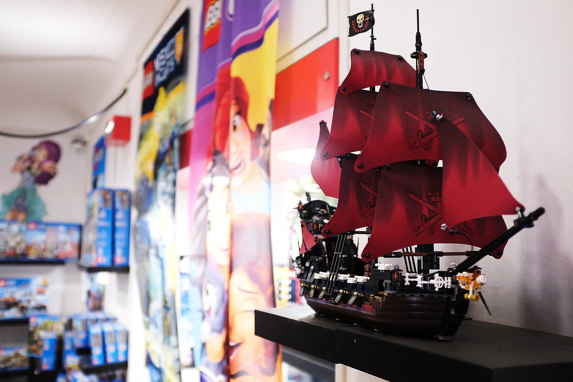 Una nave pirata lego con le vele rosse è su uno scaffale