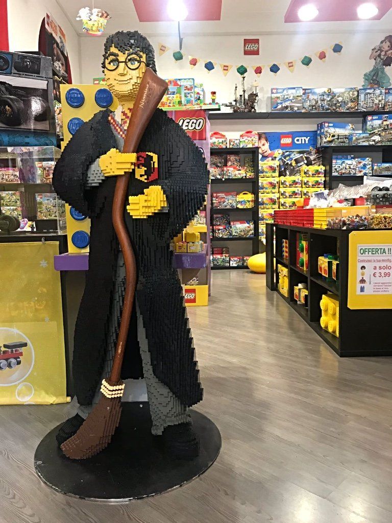Una statua Lego di Harry Potter che tiene in mano una scopa in un negozio di giocattoli.