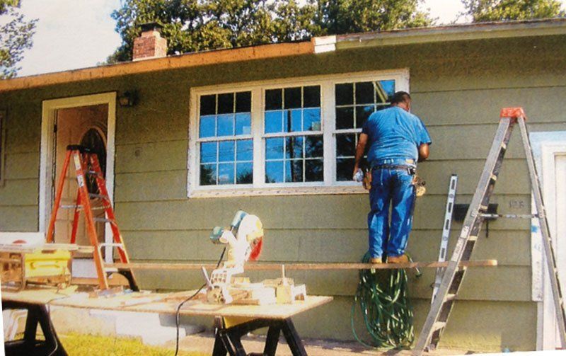 Vinyl Siding — Worker Installing Window in Ma, USA