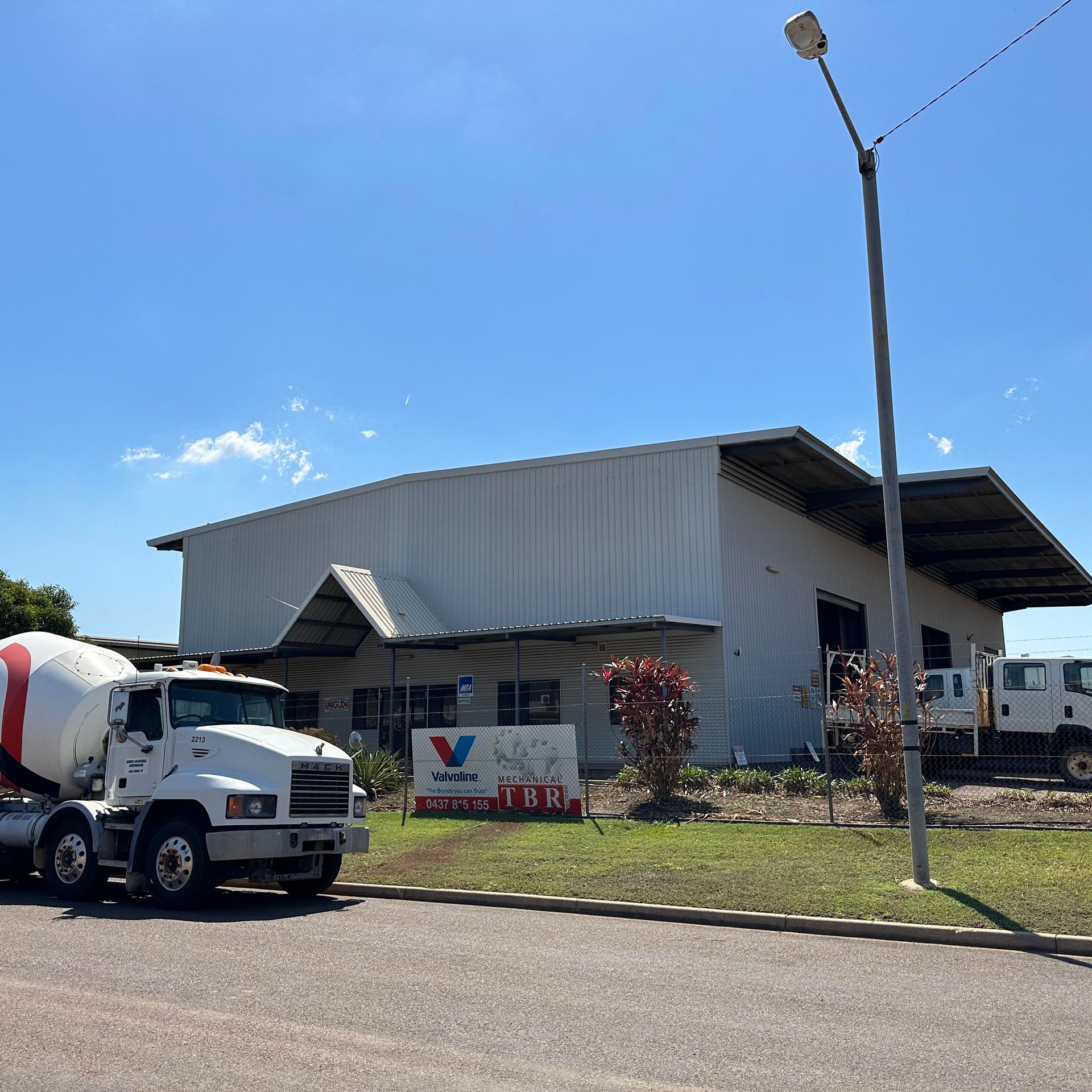 A Row Of Yellow And White Trucks Are Parked In Front Of A Building — TBR Mechanical in Berrimah, NT