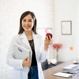 A nutritionist holding a clipboard and an apple