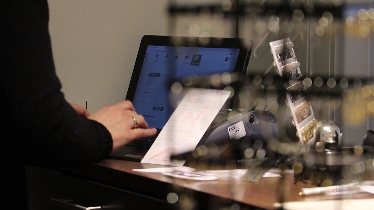 Ein Mitarbeiter  von Woudstra gibt Daten in eine Prismanote Kasse ein