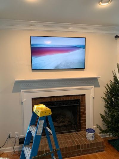 A living room with a fireplace and a flat screen tv on the wall.