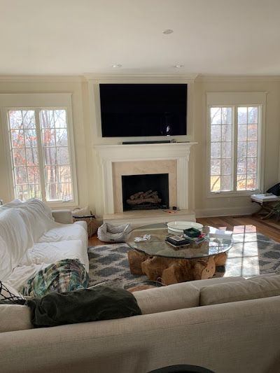 A living room with a fireplace , couch , coffee table and television.